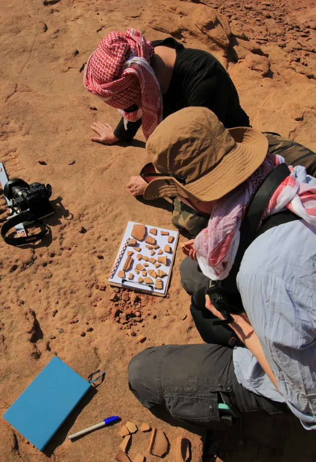 A researcher documenting an inscription in the field