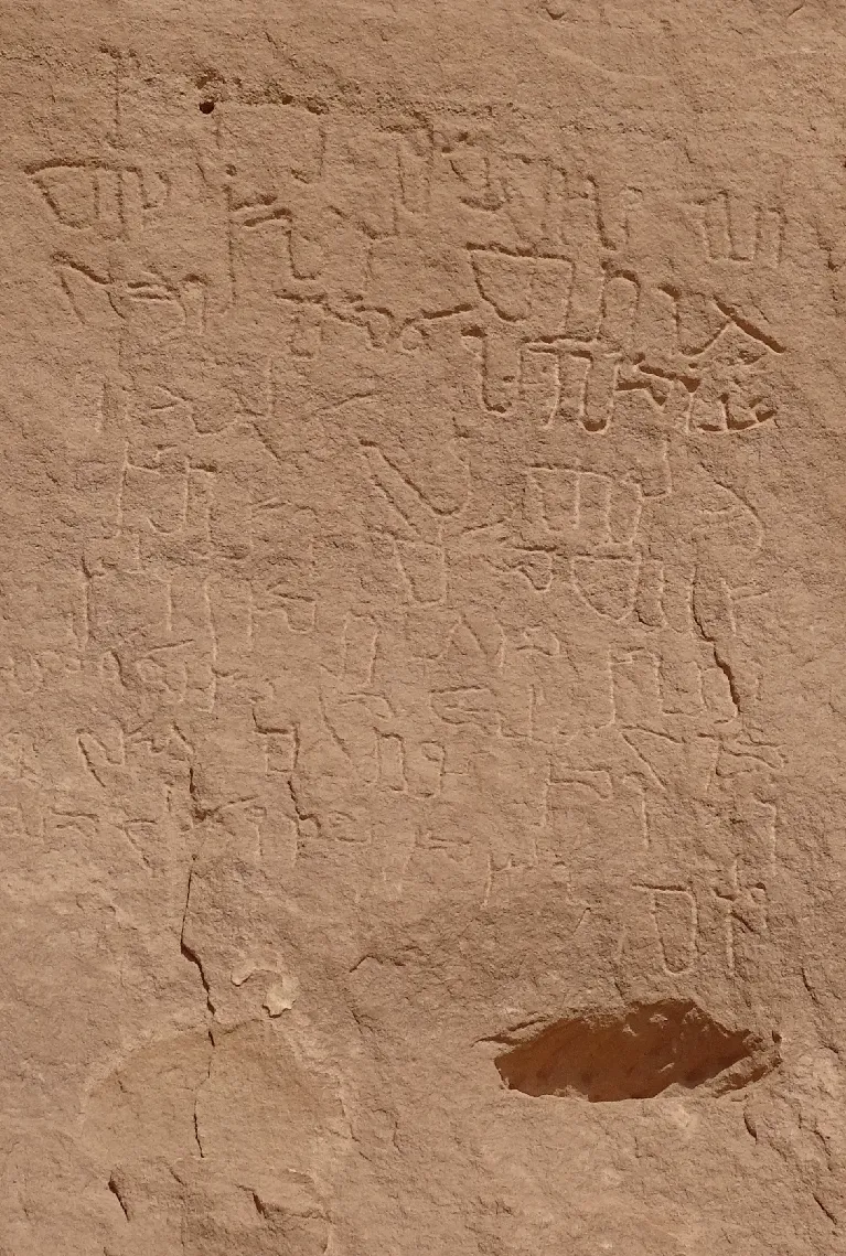 A sandstone surface incised with several lines of Nabataeo-Arabic inscription.